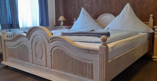 马林哈弗Landgasthof Hotel Zur Waage的一张配有白色床单和枕头的大床