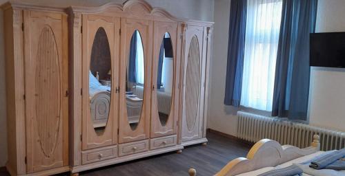 马林哈弗Landgasthof Hotel Zur Waage的一间卧室配有带镜子的大型木制橱柜