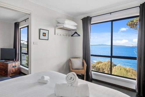 斯旺西汉普顿湾酒店的卧室设有海景大窗户