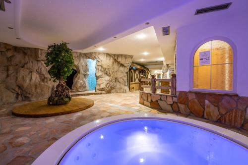 坎皮泰洛迪法萨Hotel Soreghes Gran Chalet的一个大浴室,内有植物,配有浴缸