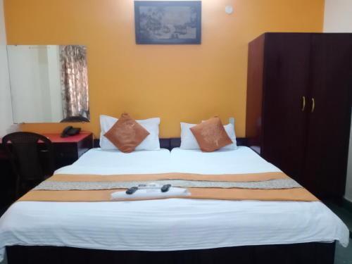 瓜廖尔Mrignayani的酒店客房设有一张带白色床罩的大床