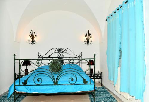 哈马马特BUNGALOW El HOUDA的一间卧室配有蓝色的床和蓝色窗帘