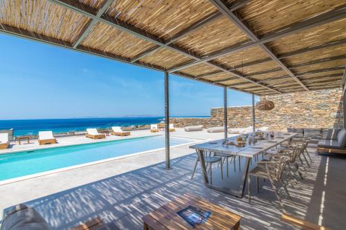 提诺斯Blue Gres Villa Tinos的一间带桌子和游泳池的用餐室