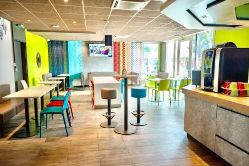 科尔马ibis Budget Colmar Centre Gare的一间设有五颜六色桌椅的餐厅和一间酒吧