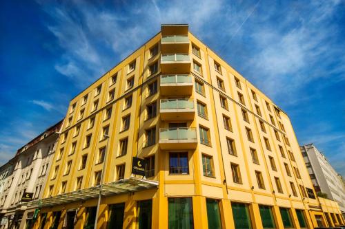 卢布尔雅那卢布尔雅那城市酒店的黄色建筑的侧面设有窗户
