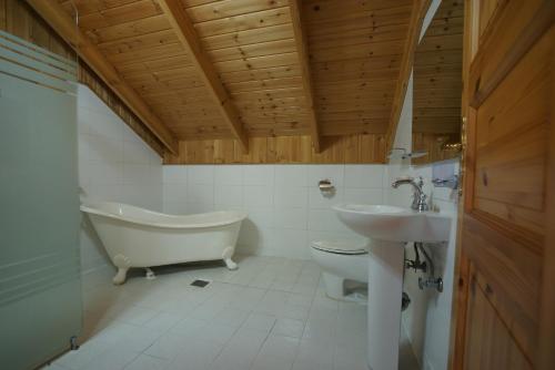 西归浦市阳光明媚济州岛度假屋的带浴缸、卫生间和盥洗盆的浴室