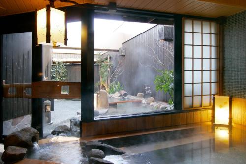 熊本多美迎熊本天然温泉酒店的一间设有水池和窗户的客房