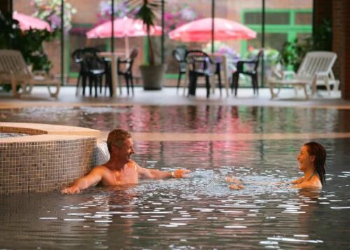 利明顿New Forest Retreat Shorefield Country Park的两人在雨中的游泳池里