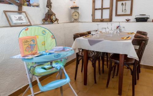 阿洛斯Hotel Pascal的用餐室配有带儿童高脚椅的桌子