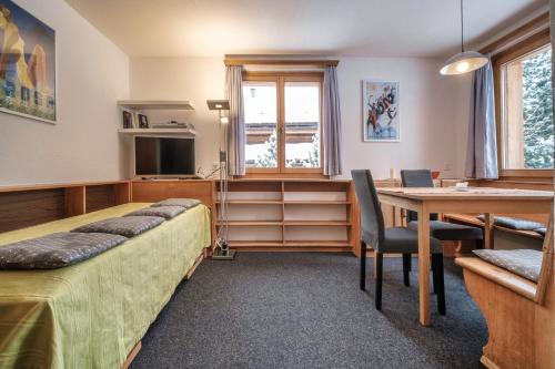 阿罗萨Chalet Höckli Wohnung 2.的一间卧室配有一张床、一张桌子和一张桌子
