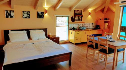 Gid‘onaAndalusian House in the Gilboa的一间卧室配有一张床铺和一张桌子,还设有一间厨房