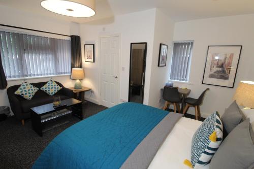 沃尔索尔Anson Studios Walsall M6, J10的一间卧室配有蓝色的床和沙发