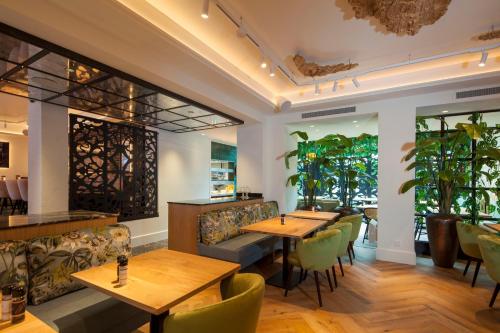 戈伊斯Boutique Hotel Jersey的餐厅设有木桌和绿色椅子