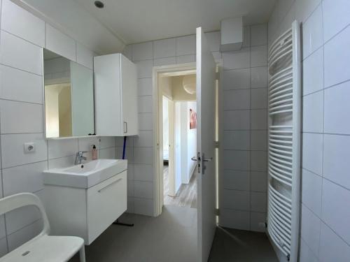 佐特兰德Vakantiewoning Scheldestraat 23 Zoutelande, dicht bij Domburg的白色的浴室设有水槽和镜子