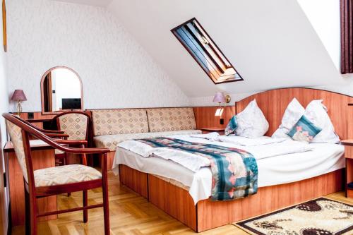 布达佩斯贝娅特丽克丝酒店的一间卧室配有一张床、一张桌子和一把椅子