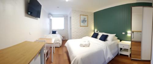 巴托湾Bay House Motel的一间卧室设有两张床和绿色的墙壁