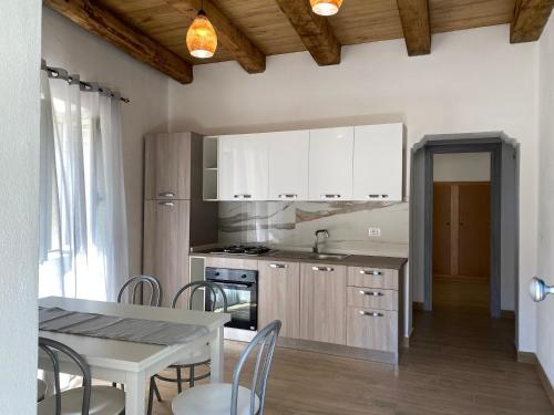 帕尔盖利亚Appartamento da Antonio的厨房配有白色橱柜和桌椅