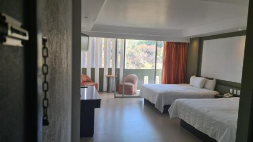 库埃纳瓦卡Hotel Borda Cuernavaca的酒店客房设有两张床和窗户。