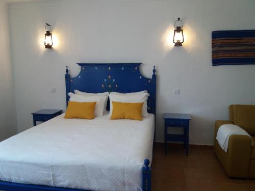 雷根古什-迪蒙萨拉什Casas da Minh'Alma的一间卧室配有蓝色的床和黄色枕头