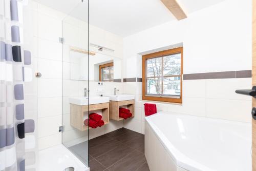 卡顿巴赫Herzstück Appartements Zillertal的白色的浴室设有浴缸和水槽。