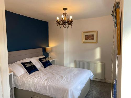 纳尔斯伯勒Custard creams cottage的一间卧室配有一张带镜子和吊灯的床。