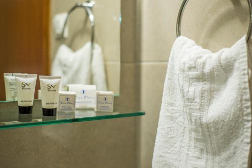 科林比亚HOTEL TINA FLORA的浴室内的架子,配有毛巾和镜子