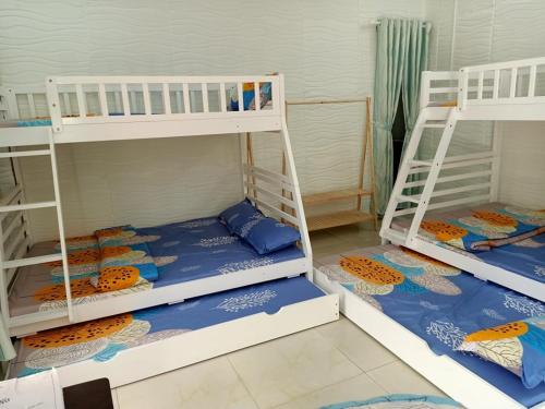 Hiếu XươngNoel Homestay的客房设有2张双层床,配有蓝色和橙色床单
