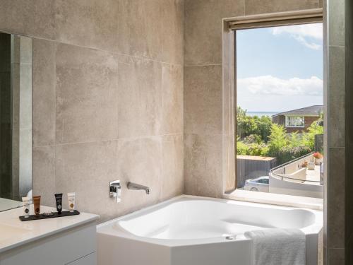奥克兰Carnmore Hotel Takapuna的带浴缸的浴室和窗户