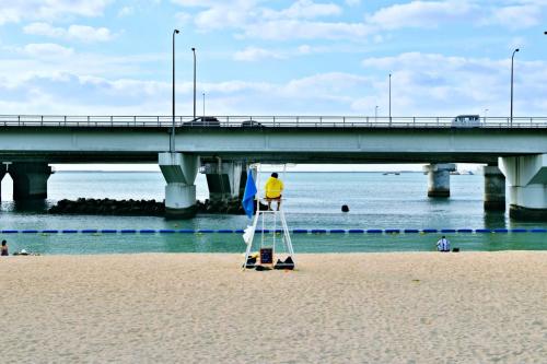 那霸TOMMY CONDOMINIUM WAKASA 601的桥边海滩上的人