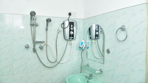 丹不拉Sayare Inn的浴室设有淋浴,墙上配有电话