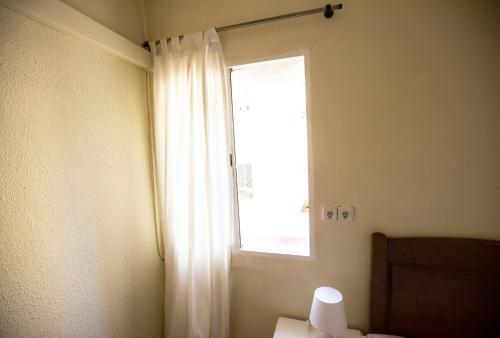 马德里Hostal Los Perales的白色窗帘的窗户