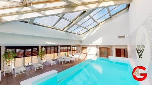 戛纳THE POOL HOUSE Cannes的一座带玻璃天花板的建筑中的游泳池