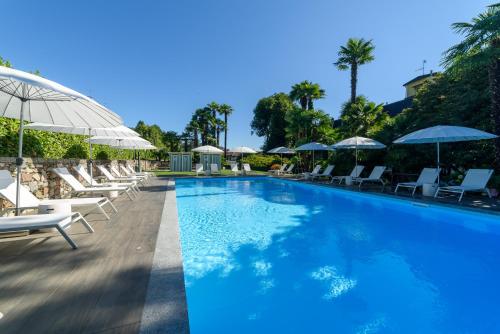 阿罗纳天堂別墅酒店的一个带躺椅和遮阳伞的游泳池