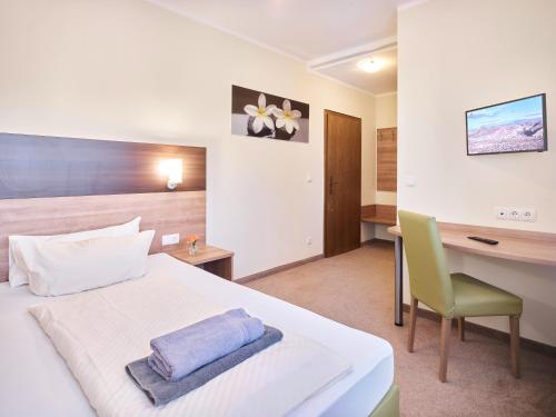 波恩Portofino的配有一张床和一张书桌的酒店客房