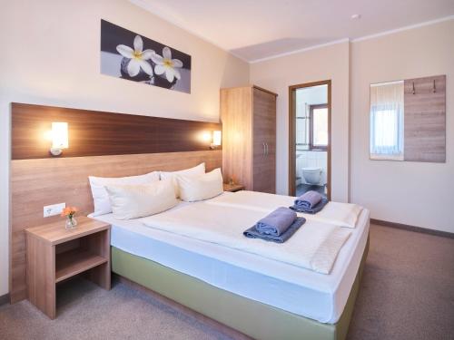波恩Portofino的卧室配有一张白色大床和木制床头板