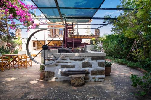 希俄斯Mansion Argyrakiko - 3 bedroom house in Kampos的庭院设有石头喷泉、桌子和椅子