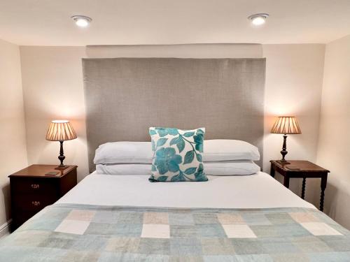马特洛克Jewel Cottage的一间卧室配有一张带枕头和两盏灯的床