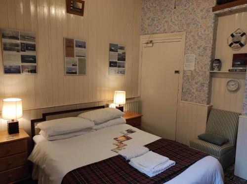 道格拉斯All Seasons Guesthouse的一间卧室配有一张床,上面有两条毛巾