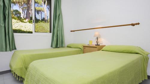 巴古尔1OP - Pals的配有绿床单的酒店客房的两张床