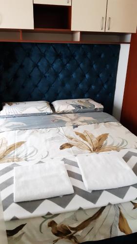 瓦列沃Apartman Ema的一张蓝色的床,上面有两条白色的毛巾