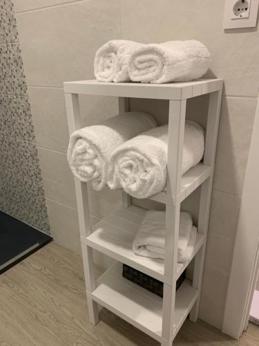 奥波里尼奥Apartamentos Sanjuan的浴室提供白色毛巾架和毛巾