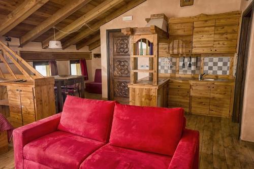 奥斯塔山羊与马住宿加早餐旅馆的带厨房的客房内的红色沙发