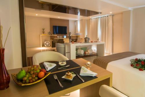 格拉玛多Modevie Boutique Hotel的一间酒店客房,配有一张桌子和一碗水果