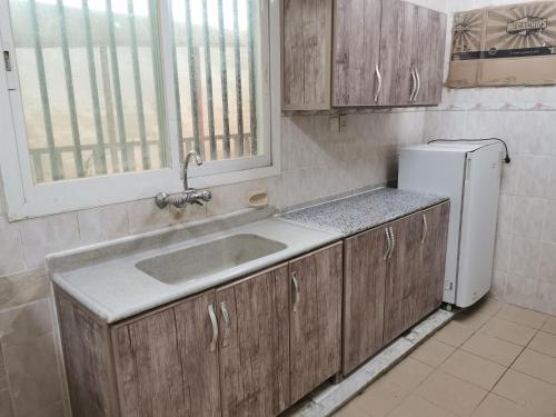 哈萨شقق عائلية مع انترنت مجاني的厨房配有水槽和冰箱