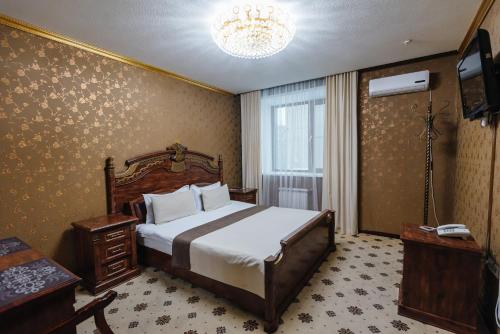彼得罗巴甫洛夫斯克Altyn Adam Hotel的一间卧室配有一张床和一台电视