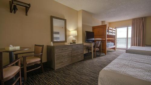 大洋城Americana Motor Inn on Boardwalk的酒店客房配有一张床、一张书桌和一台电视。