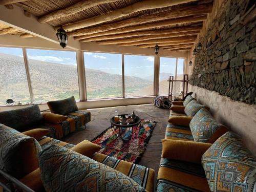 Zawyat OulmziTouda Ecolodge Atlas Mountains的带沙发和石墙的客厅