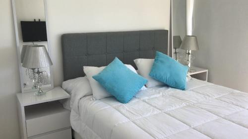 埃斯特角城Gala Vista的一间卧室配有白色床和蓝色枕头
