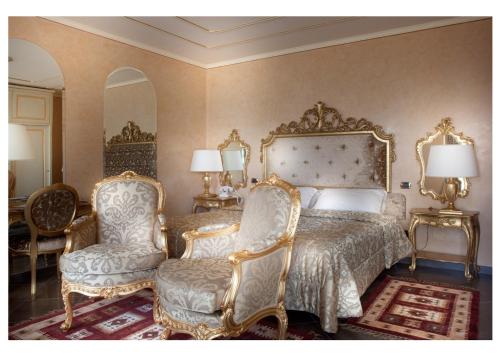加尔多内-里维耶拉Park Hotel Ville Montefiori的一间卧室配有一张床和一对椅子