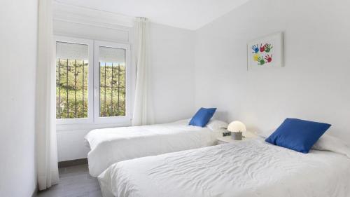 卡莱利亚德帕拉弗鲁赫尔I-51 - Calella de Palafrugell的白色客房的两张床,设有窗户